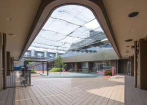 園庭 広い再生木デッキと建物に囲まれた計画、築山やクライミングウォールなど、遊び場をたくさん散りばめた。